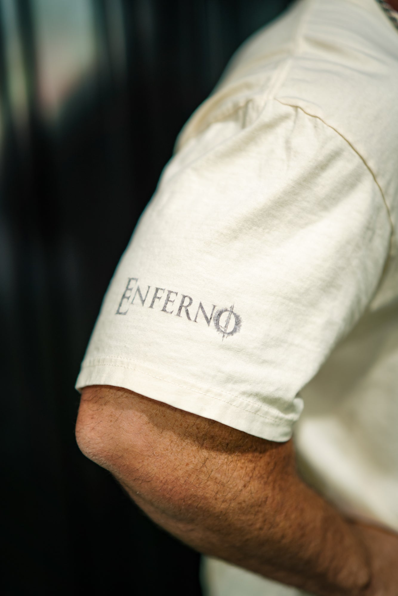 Right arm detail of Enferno Diet Face Pocket Tee in Ivory on model Grady.