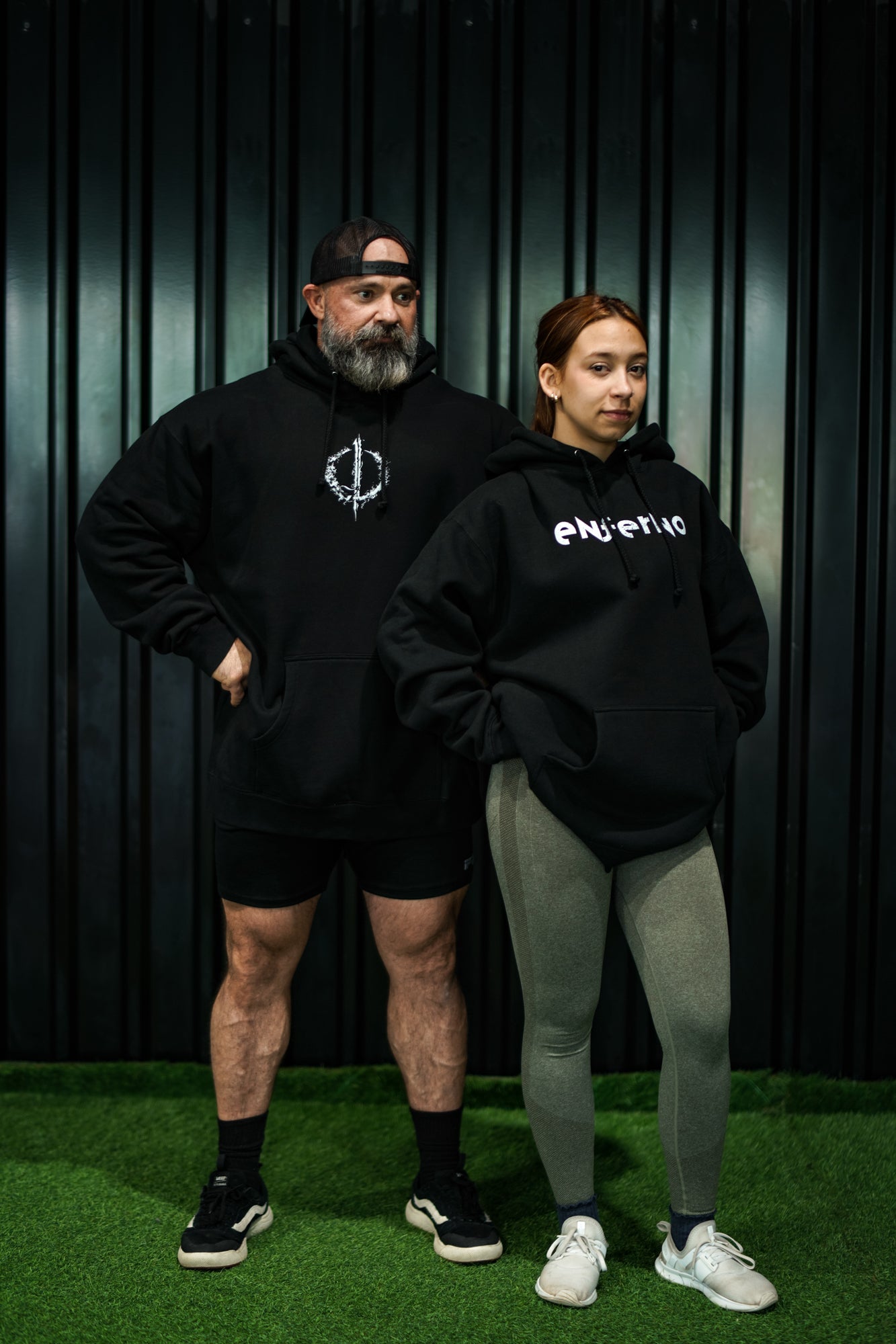 Enferno X-Ray Unicorn Hoodie in Black and Enferno Repeat Logo Hoodie in Black on models Madelyn & Grady.